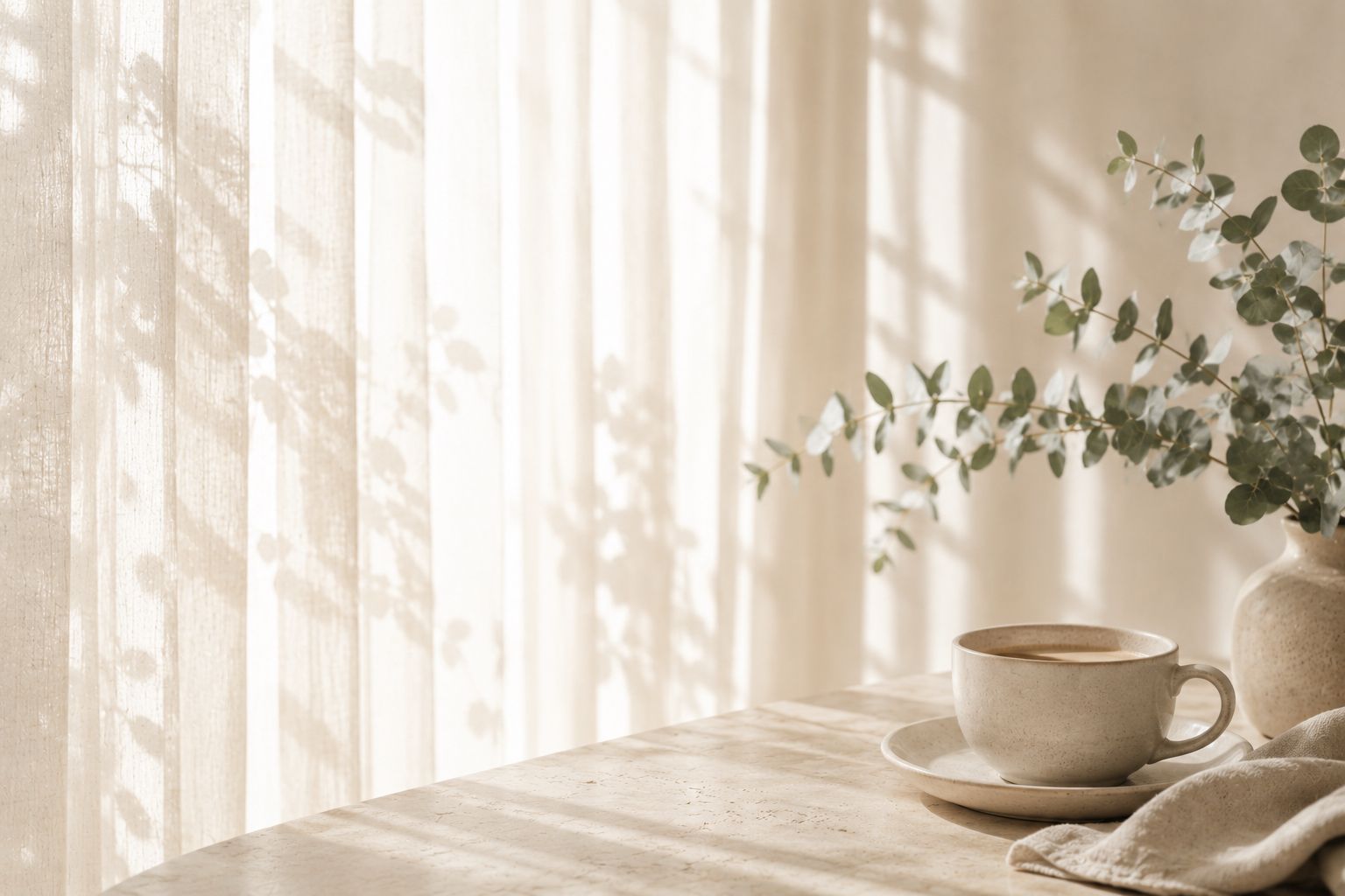 Calm, sunlit room with a eucalyptus arrangement and lit candle — evoking a sense of calm, order and care